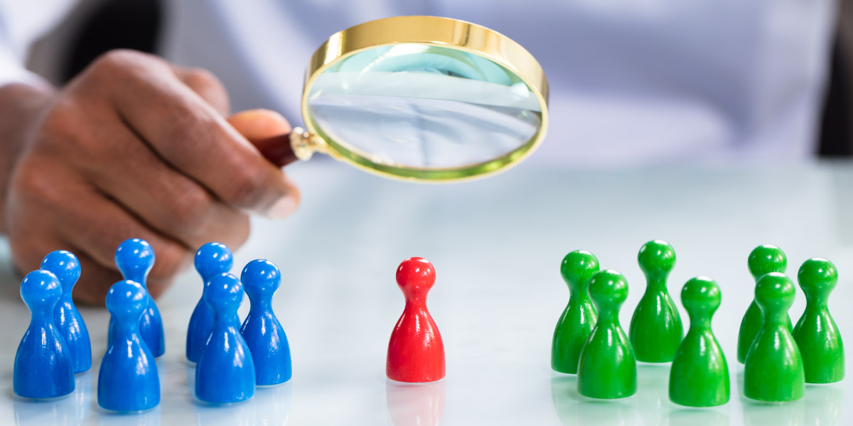 Man Looking At Colorful Pawns With Magnifying Glass